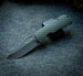 Little Dixon folding pocket knife with a dragon scale textured green handle shown open against a grey felt background
