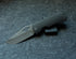 Little Dixon folding pocket knife with a smooth dark handle shown open against a grey felt background