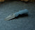Little Dixon folding pocket knife with a dragon scale textured blue handle shown open against a grey felt background